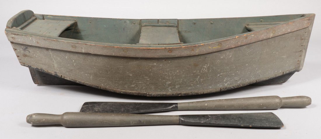 Miniature Green Painted Flat Bottomed Wood Rowboat: Miniature Green Painted Flat Bottomed Wood Rowboat with two hand carved oars. Oars painted green and black. Boat has a fixed keel/rudder painted black. Rear seat and mid seat with covered bow. Boat: 3