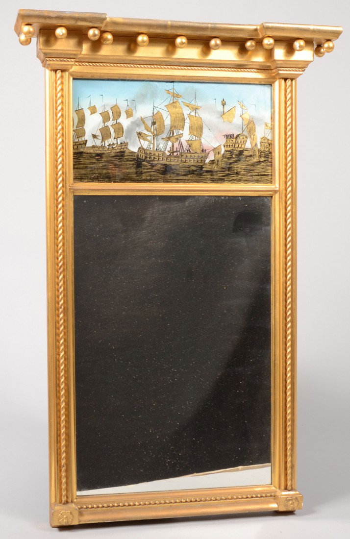 Two Part Eglomise Painted Panel Federal Style Mirr: Two Part Eglomise Painted Panel Federal Style Mirror. Top panel image of a Navel ship battle in gold and black with blue and pink sky with gray smoke. Surrounded by a gilt carved wood frame, overhangi