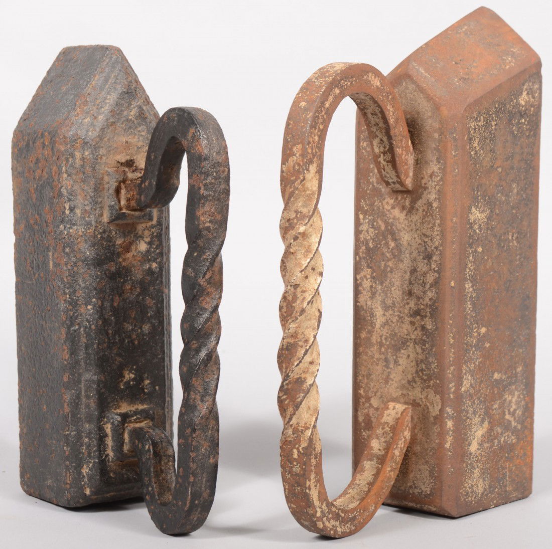 Two Cast Iron Sad Irons. Both similar, but differe: Two Cast Iron Sad Irons. Both similar, but different with twisted wrought iron handles. 7 1/2"h. X 11"l. and 6"h. X 9 1/2"l.