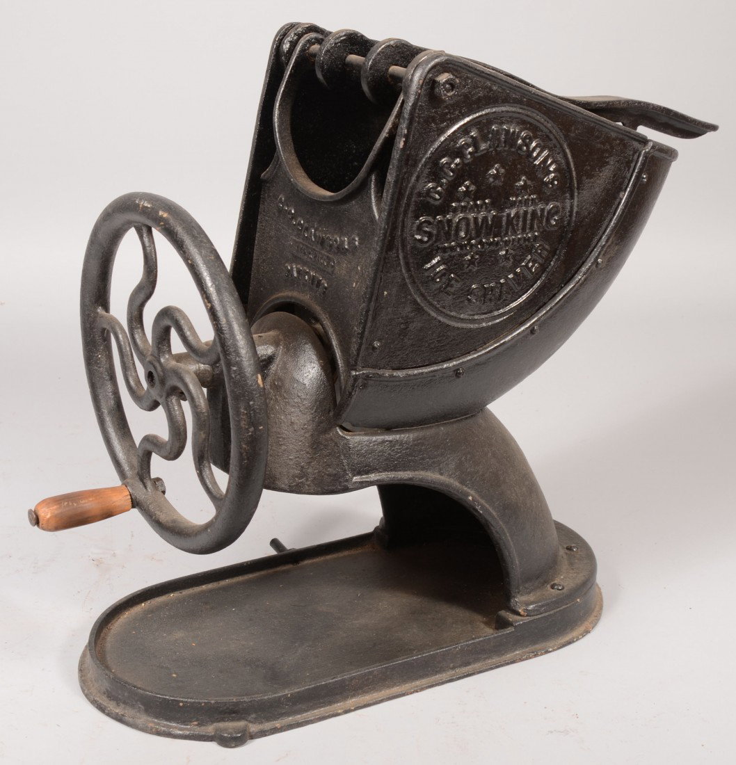 Large Cast Iron Ice Shaver. Quarter round bin with: Large Cast Iron Ice Shaver. Quarter round bin with plunger on base and crank driven blade in front. Marked: "G.C. Glawson's Snow King." 20 1/2"h. X 22"l.