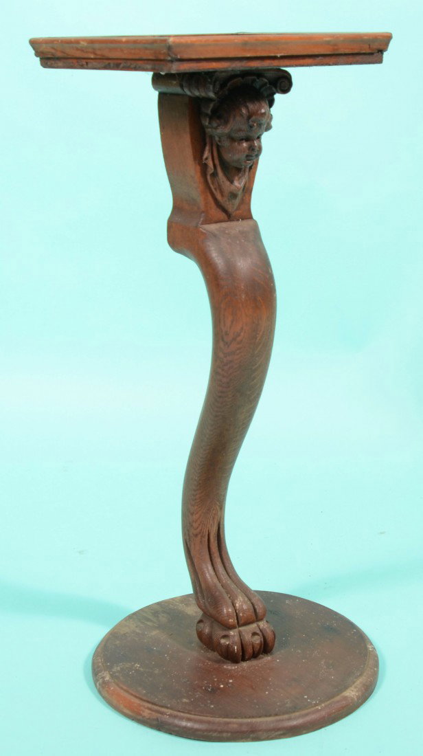 A Homemade Butler Stand. Made up of a single carve: A Homemade Butler Stand. Made up of a single carved oak cabriole table leg with paw and claw foot and applied female bust at top. Base of a molded edge circular wood pad and top of molded edge square 