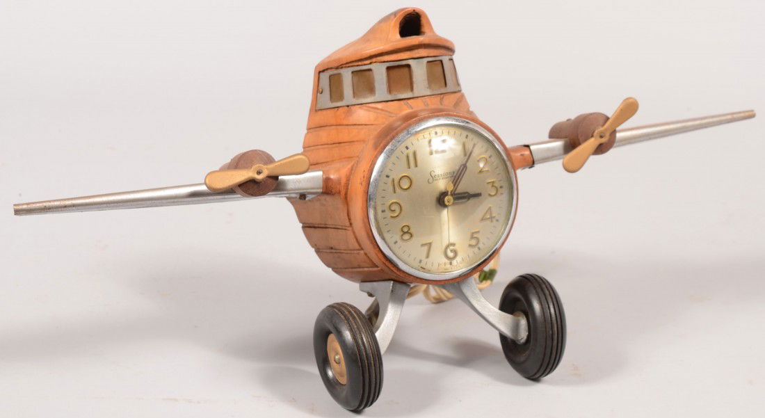 Aviator's Electric Desk Clock. Labeled "Sessions,: Aviator's Electric Desk Clock. Labeled "Sessions, Self Starting" this clock has a carved wood body resembling the fuselage of an airplane with overhead cockpit windows that light up, sheet steel wings