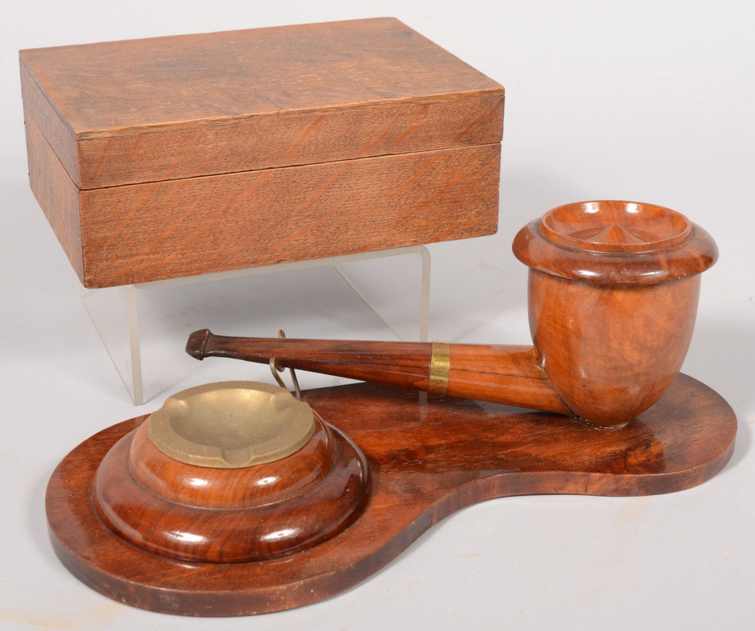 Two Tobacco Items. A pipe smoking station made up: Two Tobacco Items. A pipe smoking station made up of an oversize pipe with cover as a tobacco humidor or match container and a stamped sheet brass ashtray both mounted on a bean shaped platform all of