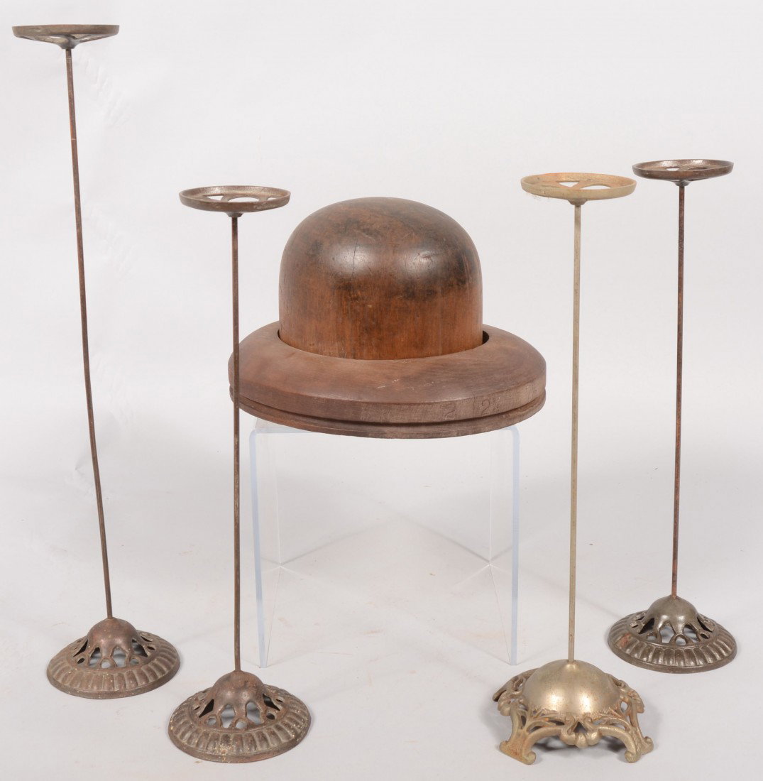 Hat Stands and Hat Mold. A carved hardwood hat mol: Hat Stands and Hat Mold. A carved hardwood hat mold for a 7 1/8 size Bowler or Derby hat. 7"h. X 11 3/4"l., Along with four cast iron based wire hat stands. Three pieces at 17 1/2"h. and one at 22 1/4