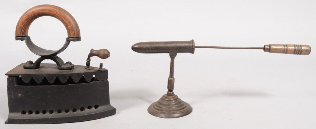 Two Early Cast Irons. A central/southern 19th cen: Two Early Cast Irons. A central/southern 19th century European charcoal iron with wood handle. 9 3/8"h. X 8 1/2". Along with a Goffering iron. Unmarked barrel on stand with wood handled heat core. 6 1