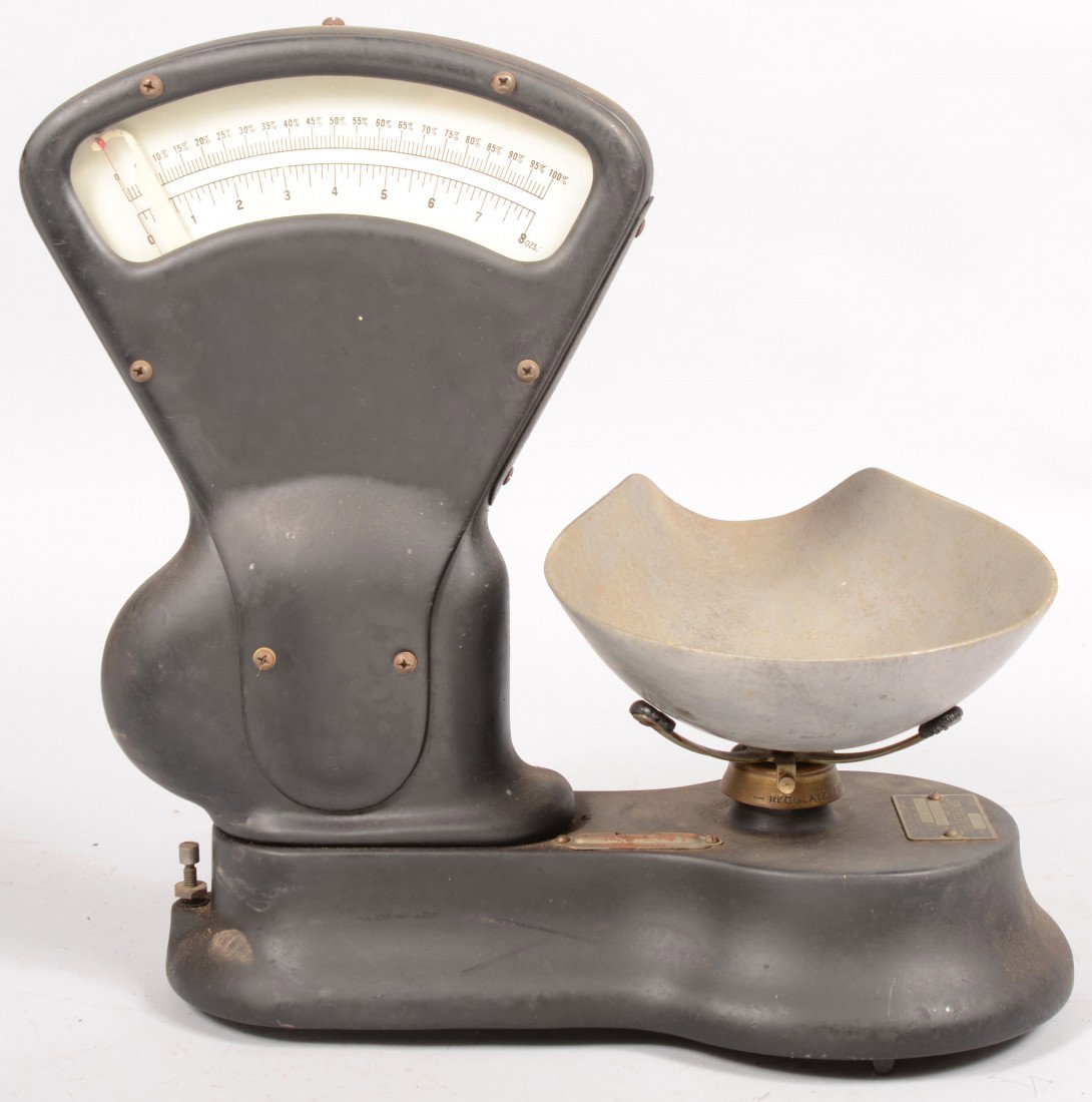 A Cast Iron Candy Scale. Mfg. by "Toledo Scale Co.: A Cast Iron Candy Scale. Mfg. by "Toledo Scale Co., Toledo, Ohio." Max. 8oz. Capacity. Black painted cast case with radius sweep dial indicator, a spirit level on case, and a cast aluminum scoop.