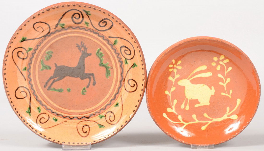 Two Turtle Creek Redware Dishes. A pink slip glaze: Two Turtle Creek Redware Dishes. A pink slip glazed dish with a running deer in center with scrolls and dots around coggle rim. 10"dia. Along with a smaller dish with a slip rabbit and posies on face.