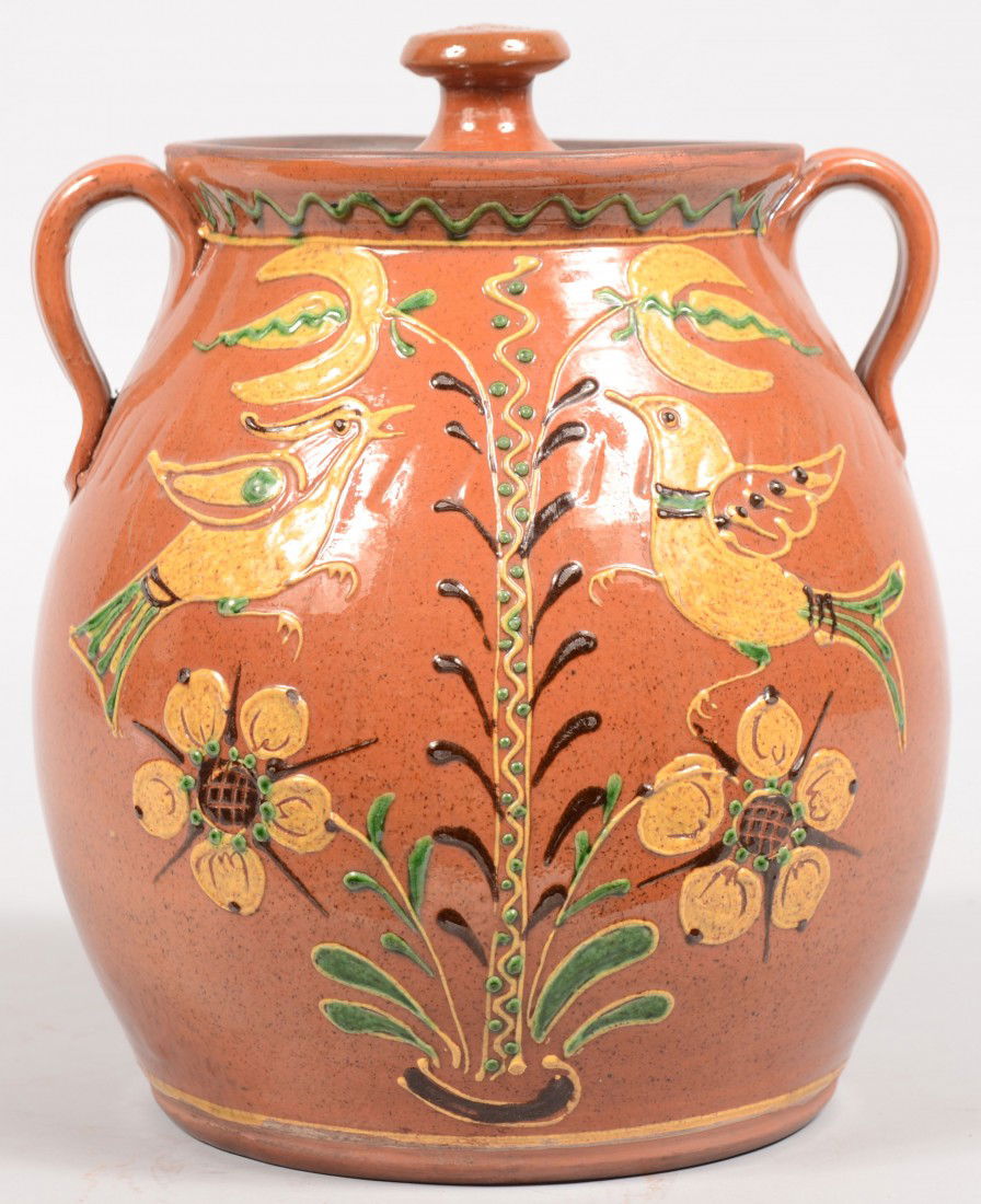 Turtle Creek Potters Decorated Redware Jar. Bulbou: Turtle Creek Potters Decorated Redware Jar. Bulbous jar with applied "hog ear" handles and a flared mouth. White and green flower tree with four blossoms and flanked by two birds. Lid has knob. 9 1/4"