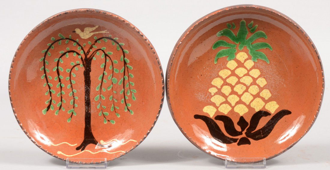 Two Slip Decorated Turtle Creek Redware Dishes. On: Two Slip Decorated Turtle Creek Redware Dishes. One with a willow tree and bird. Other with a tri-color pineapple. Both with coggle rims. Both 7 3/4"dia.