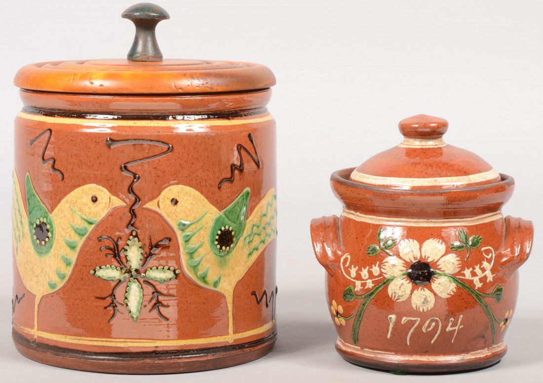 Two Covered Redware Jars by Turtle Creek Potters.: Two Covered Redware Jars by Turtle Creek Potters. A straight sided jar with a turned wood lid with knob. Jar is decorated with two facing birds, squiggle lines and floral designs. 8"h. X 6"dia. Along
