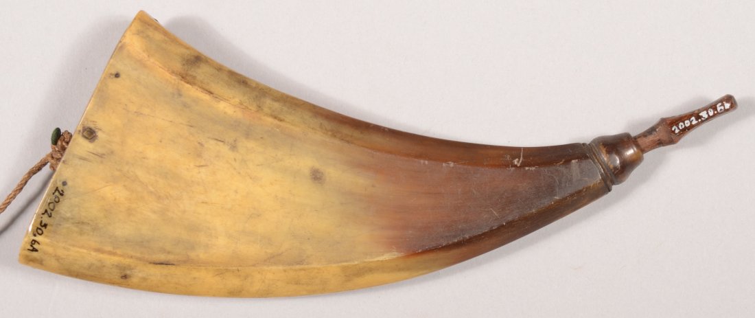 Small flat curved powder horn 6-3/4" along the out: Small flat curved powder horn 6-3/4" along the outside curve having a turned spout and a flat base plug 7/8" by 2-3/4" inscribed "J.T. PUGH 1840". Very good with a nice olive patina.