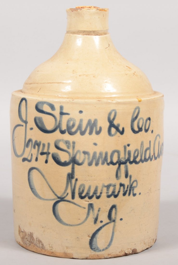 Salt Glazed Stoneware Advertising Jug. Straight sid: Salt Glazed Stoneware Advertising Jug. Straight sided body with domed jug top and applied loop handle. Inscribed on face in cobalt: "J. Stein & Co., 274 Springfield Ave., Newark, N.J." 11 1/4"h. 7"dia