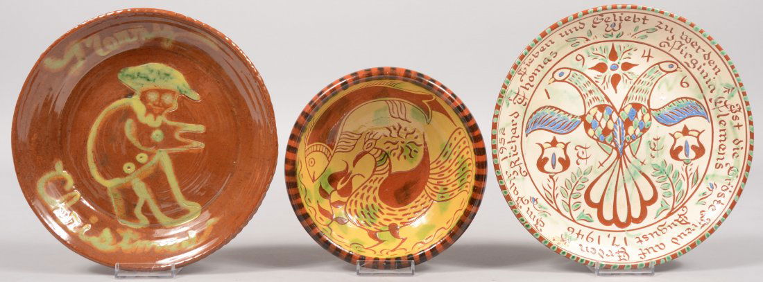 Three Slip Decorated Contemporary Redware Dishes. A: Three Slip Decorated Contemporary Redware Dishes. A Santa Claus image with "Merry Christmas" around coggle rim. Marked on back: "Made at Frog Hollow by S. J. Rhoads, 1973." 9"dia.; a white, blue, yell
