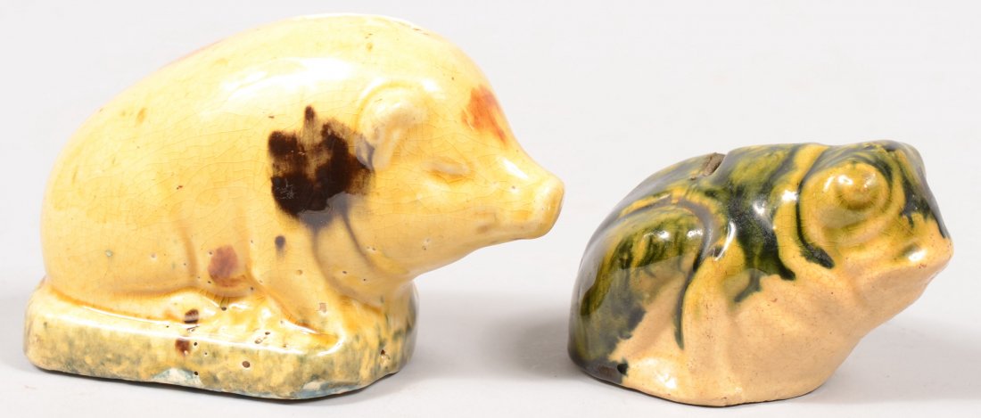 Two Glazed Stoneware Animal Coin Banks. A seated p: Two Glazed Stoneware Animal Coin Banks. A seated pig in with manganese spots and cobalt on base which appears green under the overall yellow cast overglaze. 4"h. X 5 1/2"l. Along with a seated frog wi
