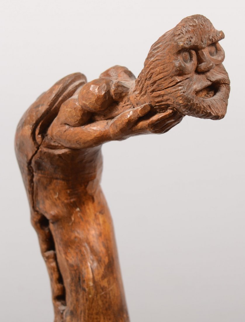 Carved Wooden Cane. Featuring a bearded man's head: Carved Wooden Cane. Featuring a bearded man's head with arms and hands holding under his chin and protruding from the end of the staff. Balance of staff natural, no tip. 39"l. X 5 1/2"w. at crook.