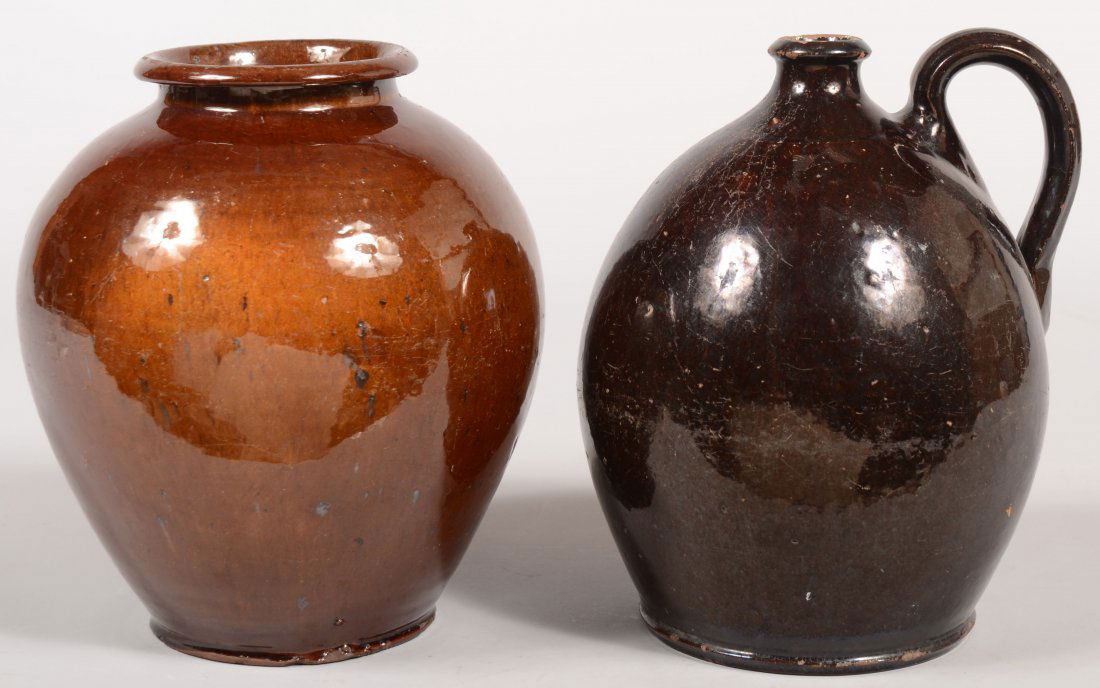 Two Pennsylvania 19th Century Bulbous Form Redware: Two Pennsylvania 19th Century Bulbous Form Redware Pottery Pieces; Jug with flared collar spout and manganese glaze, 9 3/4"h. and a storage crock with flare rim and molded base, 9 1/2"h.