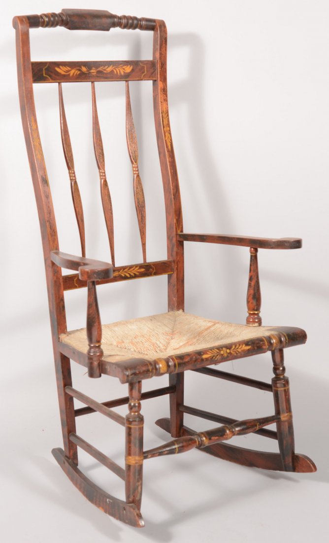 Red and Black Grain Paint Decorated Rocking Chair.: Red and Black Grain Paint Decorated Rocking Chair. Urn of fruit stenciled crest rail with banister back, scrolled arms, rush seat and turned legs and stretcher. Seat height 15 1/2", 45" high overall.