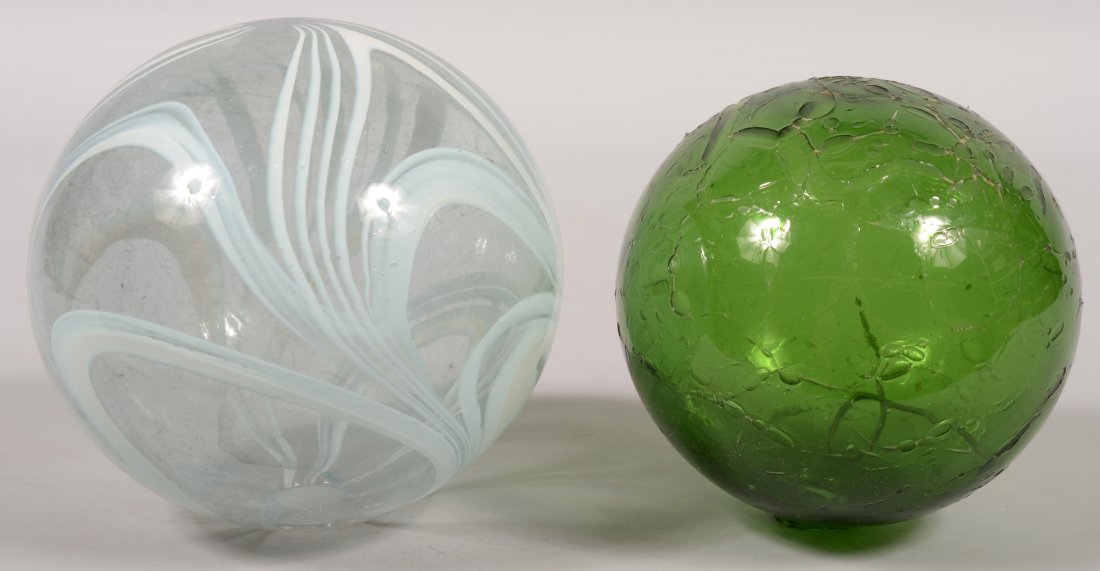 Two Colored Witches Balls. A white swirled pattern: Two Colored Witches Balls. A white swirled pattern in a colorless ball with open pontil. Possibly Nailsea glass. 6 1/2"dia. Along with a green ball with crackle over finish and open pontil. Possibly B