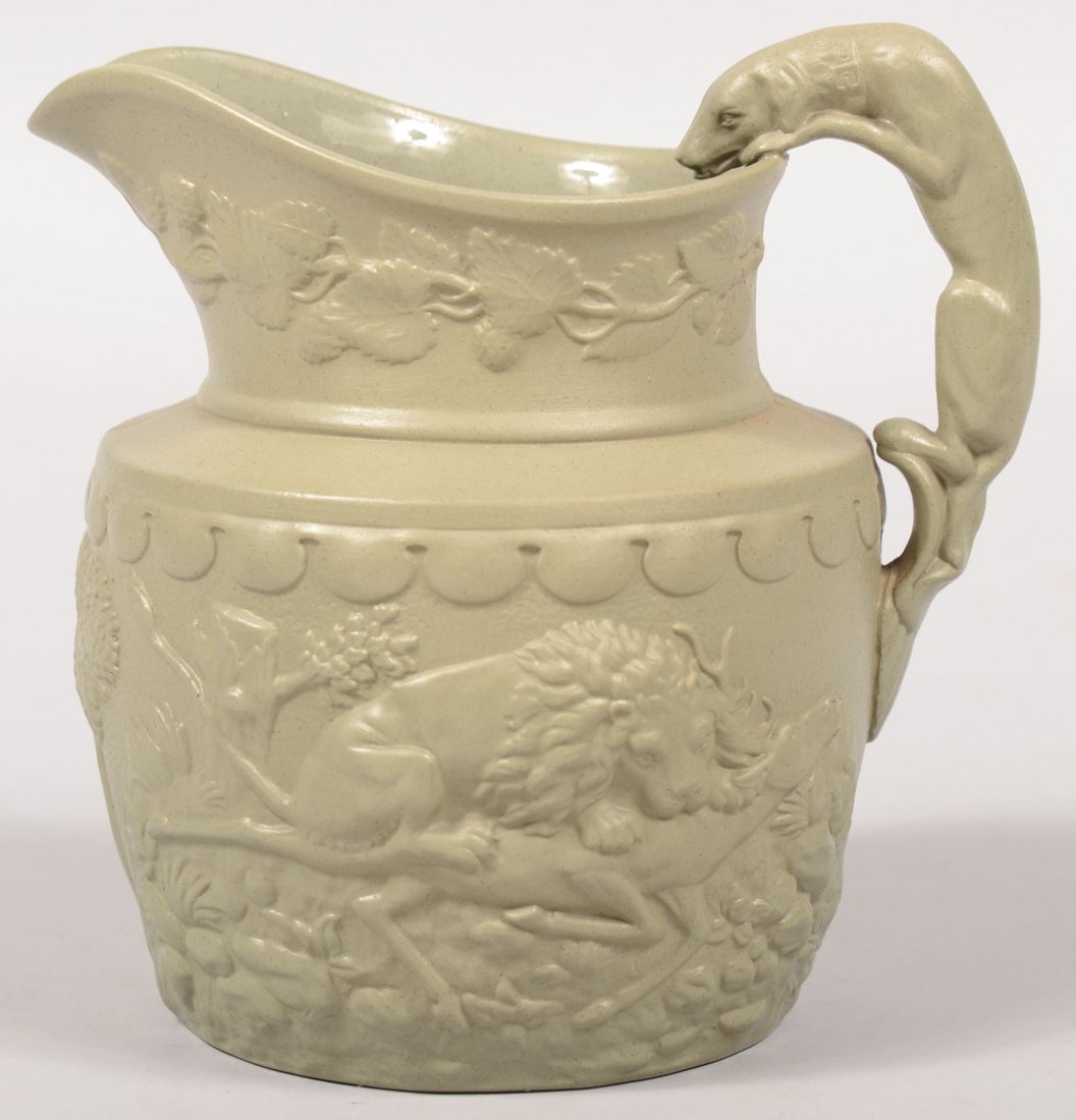 Grey Green Parian Pitcher. Relief imagery of a lio: Grey Green Parian Pitcher. Relief imagery of a lion dispatching a buck deer on one side and a bear fighting a pack of wild dogs on other. Berries, leaves and vines entwined around neck. Applied full b