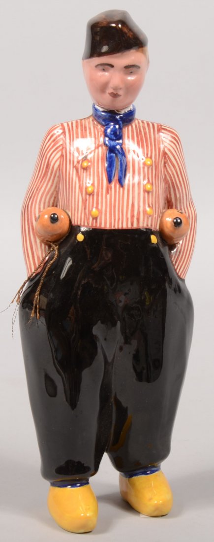Dutch Boy Form Glazed China Bottle. Dressed in blu: Dutch Boy Form Glazed China Bottle. Dressed in blue pantaloons with a red and white striped double breasted shirt, blue kerchief, yellow wooden shoes and a brown pointed cap. Carrying two bottles of "
