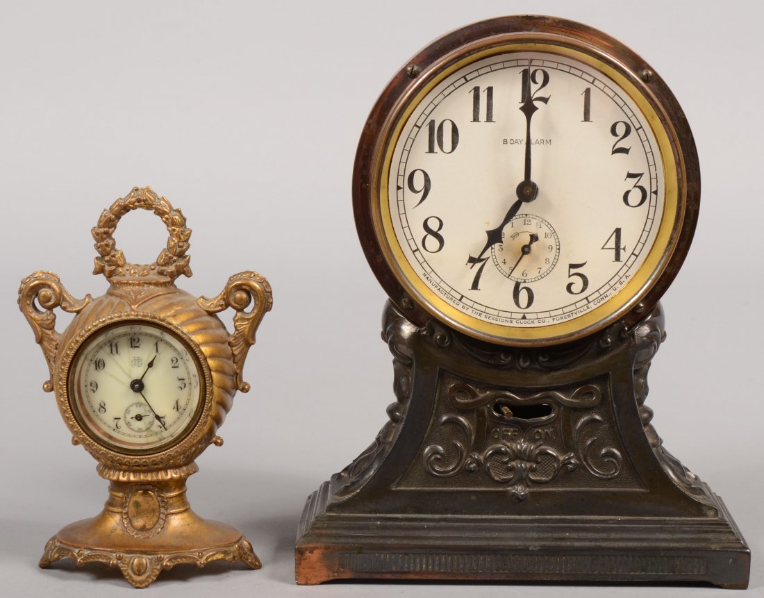 Two Cast Metal Standing Clocks. Larger is a spring: Two Cast Metal Standing Clocks. Larger is a spring driven Eight-Day alarm clock mfg. by "Sessions Clock Co., Forestville, Conn." and dated on back: "Dec. 31, 1912." 8 1/2"h. Along with a smaller sprin