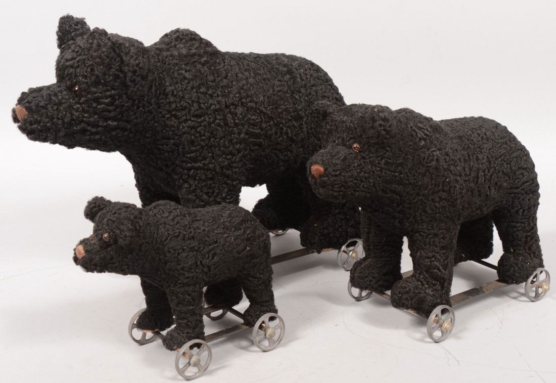 Three Graduated Toy Black Bear Pull Toys. Strap ir: Three Graduated Toy Black Bear Pull Toys. Strap iron frame with four cast tin spoked wheels. Bears have a curly lamb coat with brown thread nose and glass eyes. All signed on front paw pads: "M.E. Bea