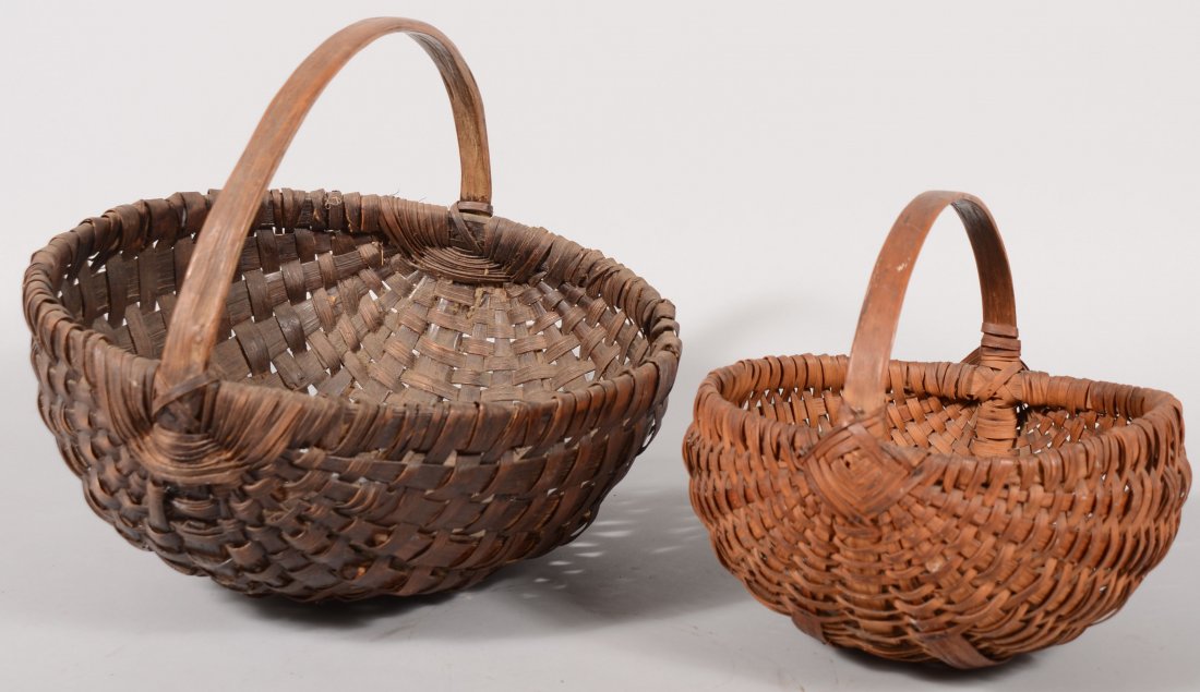 Two Stained Split Oak Melon Shaped Baskets. Larger: Two Stained Split Oak Melon Shaped Baskets. Larger has loop handle with added rib re-enforcements on bottom. 14"h. X 15 1/2"dia. Along with a smaller and lighter color model with loop handle and appli
