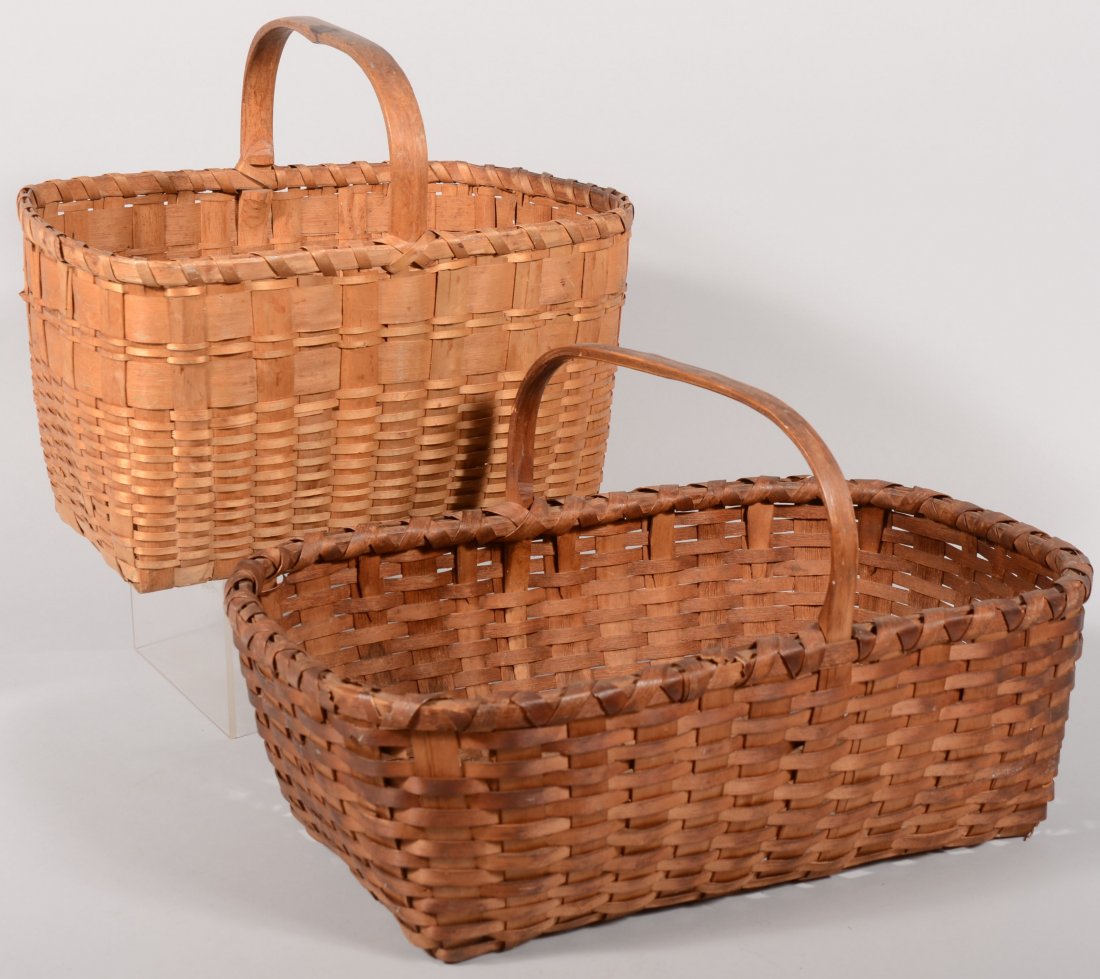 Two Market Type Baskets. A rectangular split ash e: Two Market Type Baskets. A rectangular split ash example with notch and grip carved stirrup handle. 14 1/4"h. X 17"l. X 12"w. A larger split oak example with notch carved stirrup handle. 12 1/2"h. X 2
