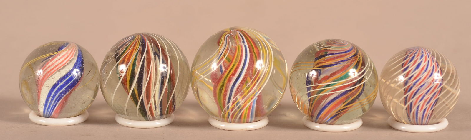 Five Antique Multicolor Divided Core Marbles.: Five Antique Multicolor Divided Core Marbles. With outer decoration consisting of sets of yellow and white latticino. 1-3/8" to 1-3/4" diam.