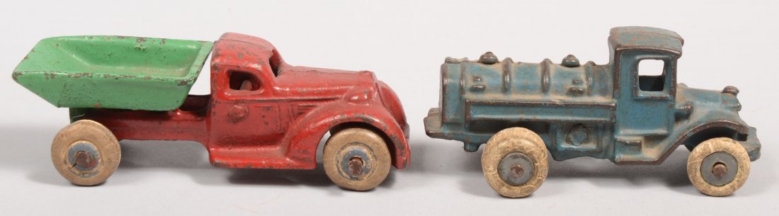 Two Small Toy Trucks. Both painted cast iron. A red: Two Small Toy Trucks. Both painted cast iron. A red and green working dump truck with white rubber wheels and marked: "Arcade" inside cab. 1 1/2"h. X 4 1/4"l. Along with a small blue tanker truck with