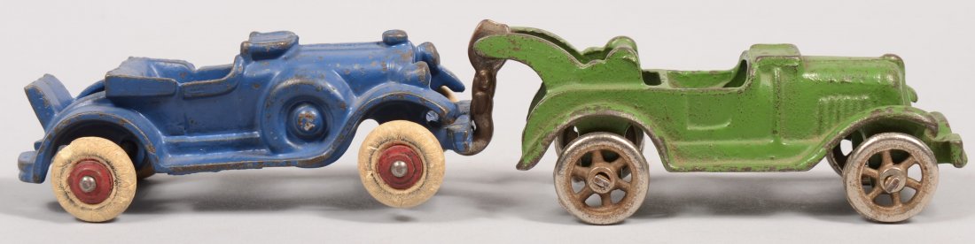 Two Hubley Cast Iron Vehicles. A green painted topl: Two Hubley Cast Iron Vehicles. A green painted topless tow truck with windshield down, swinging hook and plated cast iron spoke wheels. 5"l. Along with a topless touring car with windshield down and r