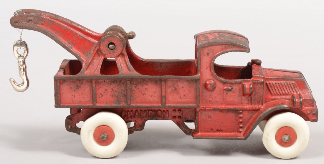 Red Painted Champion Cast Iron Wrecker. Maker's na: Red Painted Champion Cast Iron Wrecker. Maker's name on frame rail under bed. Mack style "C" cab with hoist gantry on truck bed walls with nickel plated crank, windlass and replacement hook. Truck as 