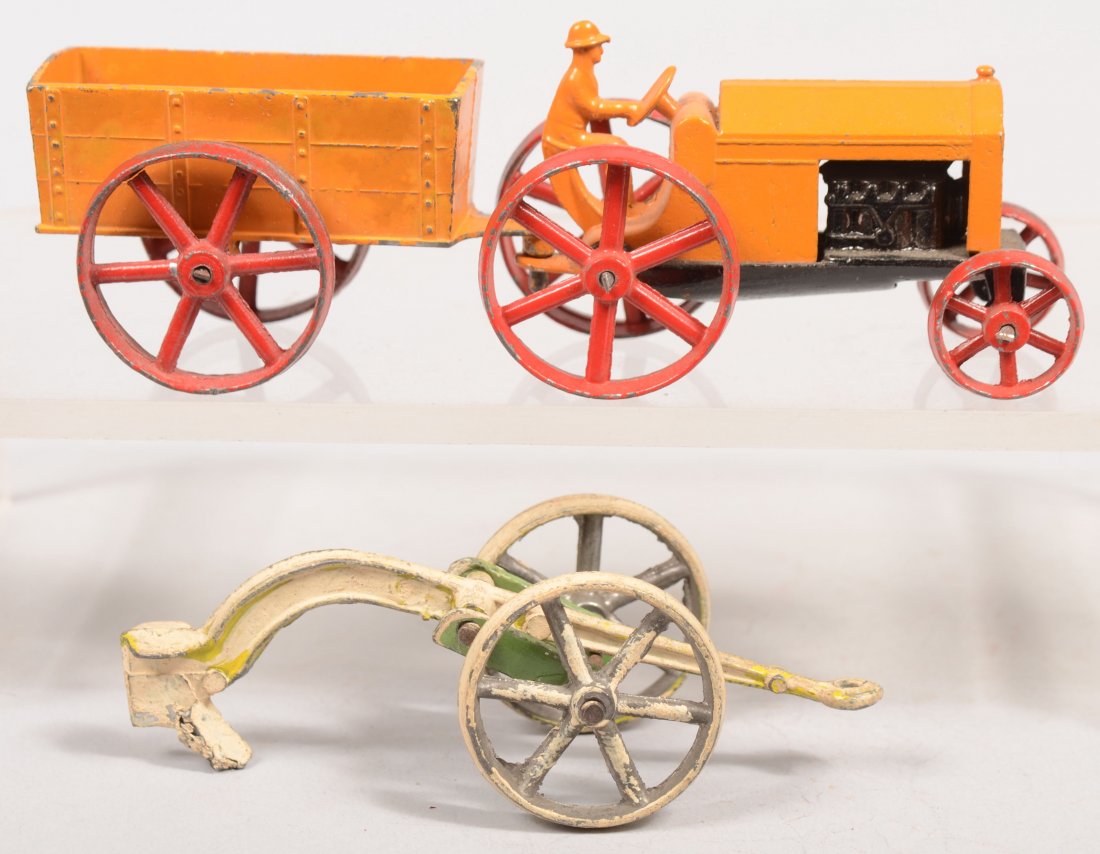 Tootsietoy Farm Tractor with Wagon and Plow. Model: Tootsietoy Farm Tractor with Wagon and Plow. Model 4654 tow piece cast tractor in orange and black paint with red wheels. Wagon in orange and red. Plow is white with green. Tractor: 1 15/16"h. X 3"l.,