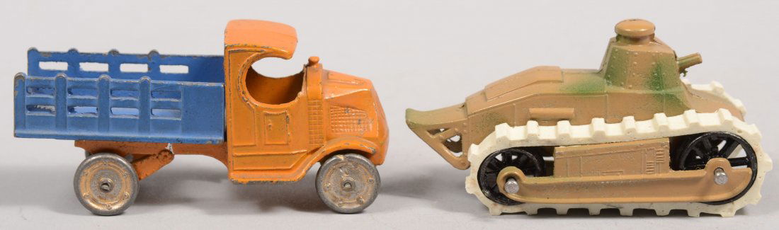 Two Tootsietoy Vehicle Toys. A World War 1 Army ta: Two Tootsietoy Vehicle Toys. A World War 1 Army tank in camouflage paint with black wheels and white rubber tracks. 3 1/8"l. Along with a yellow Mack "C" cab truck with a blue stake bed and silver cas