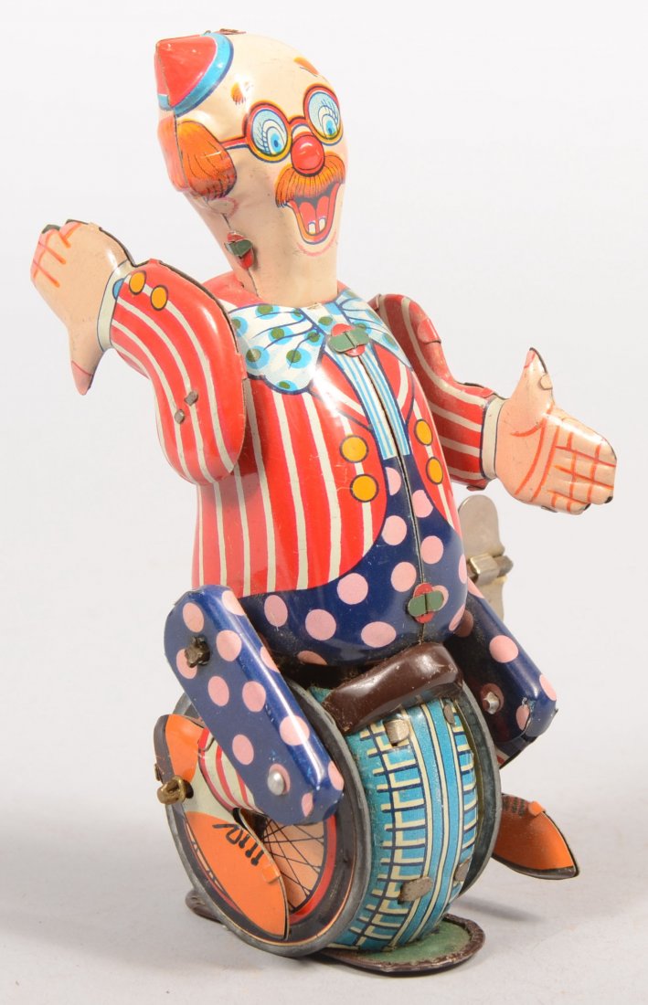 A Crazy Clown on a Unicycle Wind-up Action Toy. Po: A Crazy Clown on a Unicycle Wind-up Action Toy. Polychrome lithography decorates this toy marked only: "Japan" on back. Possibly Linemar. Clown cycles forward, stops, changes direction and continues a
