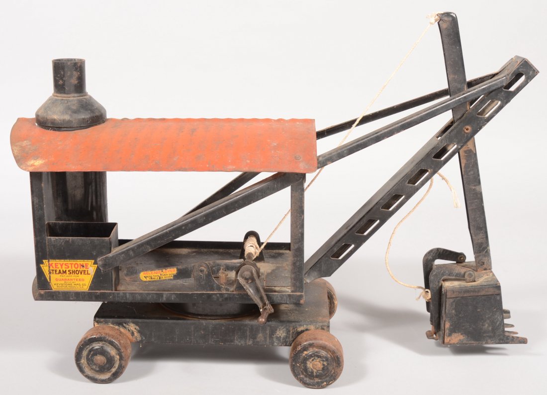 A Painted Pressed Steel Steam Shovel. Black body w: A Painted Pressed Steel Steam Shovel. Black body with corrugated red roof. Decal label: "Keystone Steam Shovel, Keystone Mfg., Boston, Mass." Four wooden wheels, 12 1/4"h. at boom X 20"l. to end of bo