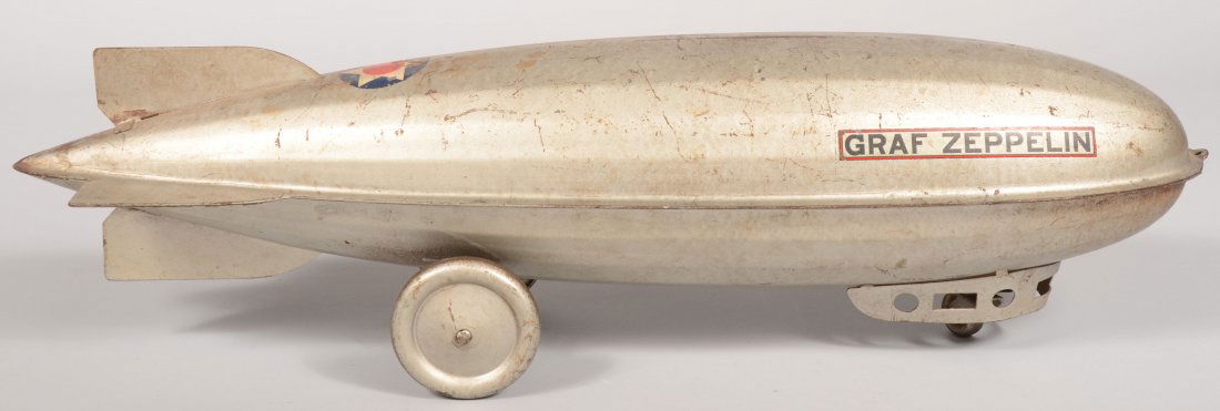 Silver Pressed Steel "Graf Zeppelin" Riding Toy. T: Silver Pressed Steel "Graf Zeppelin" Riding Toy. Two pressed steel rear wheels and a steel caster wheel at front inside gondola. Four fins with two title decals on front and a circled six point star o