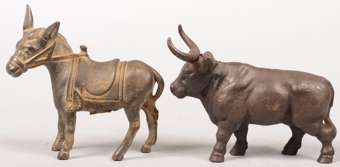 Two Cast Iron Animal Still Banks. A Donkey with sa: Two Cast Iron Animal Still Banks. A Donkey with saddle produced by Arcade or A.C. Williams, 1910 - 1934. Remnants of gold paint. 4 3/8"h. X 4 1/2"l. Together with a Long Horn Bull, U.S. made. 3 3/4"h.