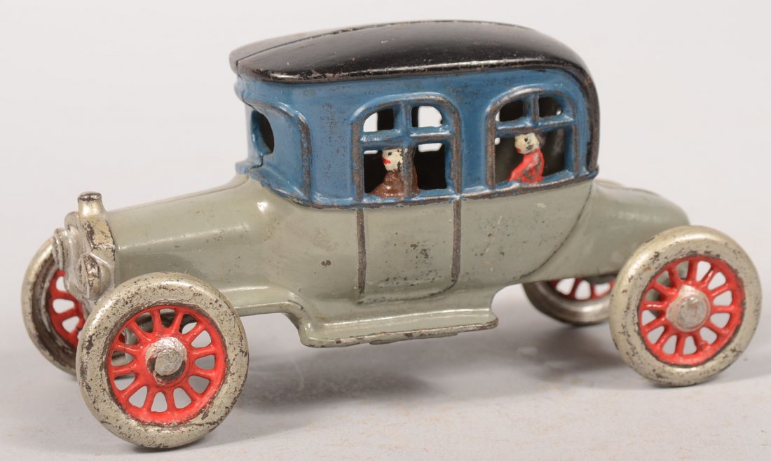 Painted A.C. Williams Three Passenger Automobile B: Painted A.C. Williams Three Passenger Automobile Bank. C. 1910 gray body with blue and black top with three passengers at the windows. Wheels are silver with red spokes. 3 1/4"h. X 6 1/4"l.