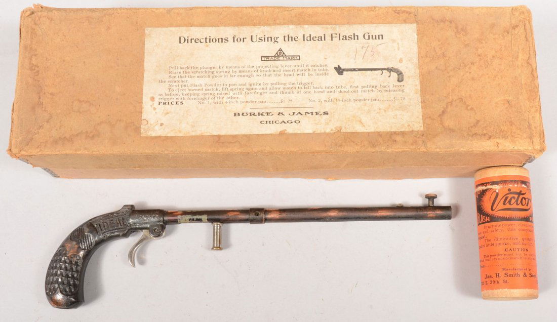 Ideal Flash Gun in Original Box. Long barreled pis: Ideal Flash Gun in Original Box. Long barreled pistol has a copper rubbed finish with nickel plated triggers. Pistol marked: "IDEAL, Burke & James, Chicago." In original box with an empty wood caniste