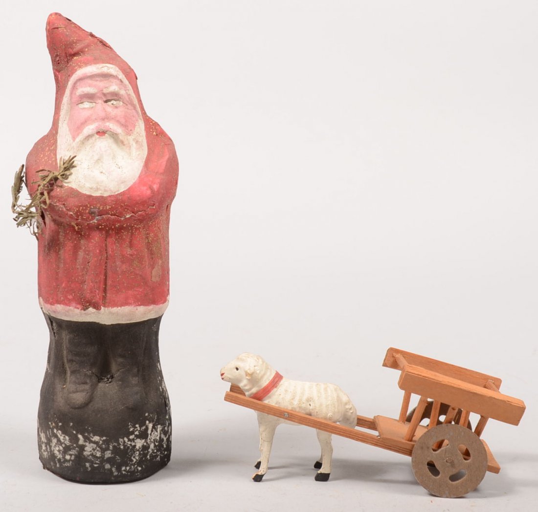 Molded Paper Mache Santa with Lamb and Cart. Santa: Molded Paper Mache Santa with Lamb and Cart. Santa painted red and white with pink face, black base accented with gold glitter and sprig of faux evergreen. No maker mark. 8 3/4"h. Along with a painted