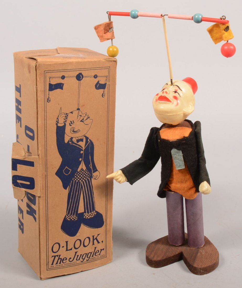 "O-Look, The Juggler" an Irwin Product, No. 390. A: "O-Look, The Juggler" an Irwin Product, No. 390. A colorful felt dressed wire form with wood feet base. Cellulose clown head rests on wire arbor from wind-up motor which gyrates and spins balance beam