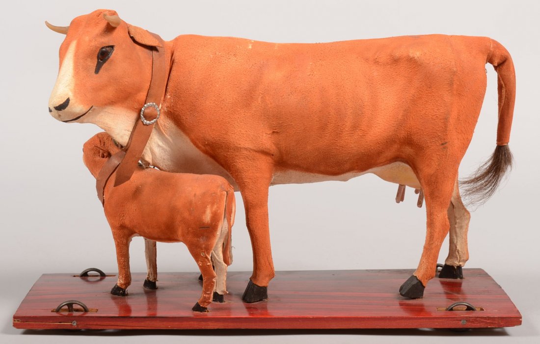 Painted Squeek Pull Toy Cow and Calf on Platform.: Painted Squeek Pull Toy Cow and Calf on Platform. Red and brown faux grained wood platform with cast iron spoked wheels supporting painted kid leather cow and calf with carved real cow horns, leather