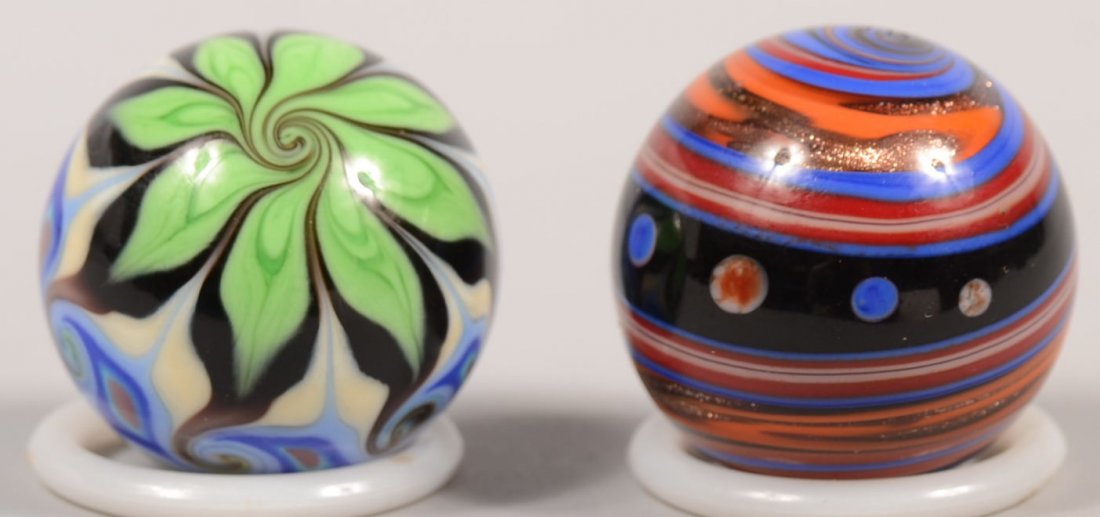 Two Signed Contemporary Handmade Glass Marbles. A : Two Signed Contemporary Handmade Glass Marbles. A multi-colored Temari type marble signed: "Hulet, 95" in greens, blues, green, white and black/brown. 1 3/16"dia. Along with a semi-opaque swirl of bla