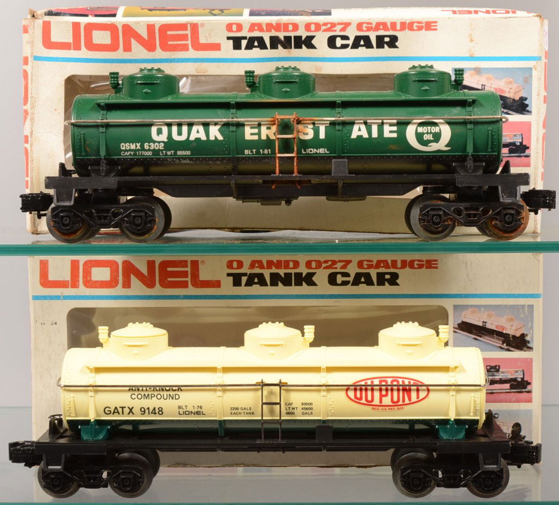 Two Lionel Triple Dome Tank Cars. A green Quaker S: Two Lionel Triple Dome Tank Cars. A green Quaker State, 6302, with white lettering. Along with a yellow and green DuPont, 9148, with red logo and black lettering. Both with boxes.