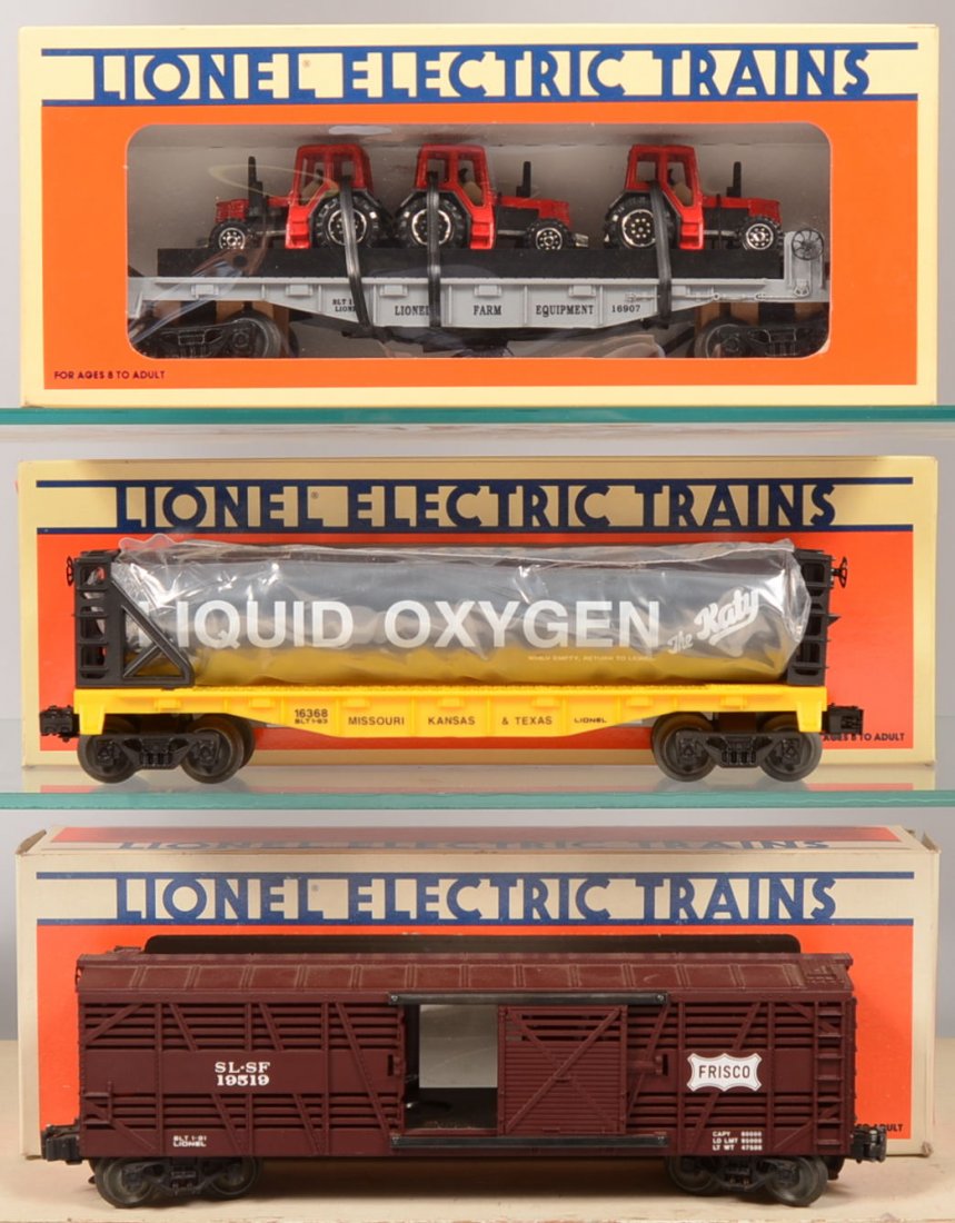 Three Modern Lionel Rail Cars. 16368, MK&T "The Ka: Three Modern Lionel Rail Cars. 16368, MK&T "The Katy" Liquefied Oxygen Car in black and yellow; 16907, Lionel Farm Equipment Flatcar with three red enclosed cab farm tractors; 19519, brown Frisco Stoc