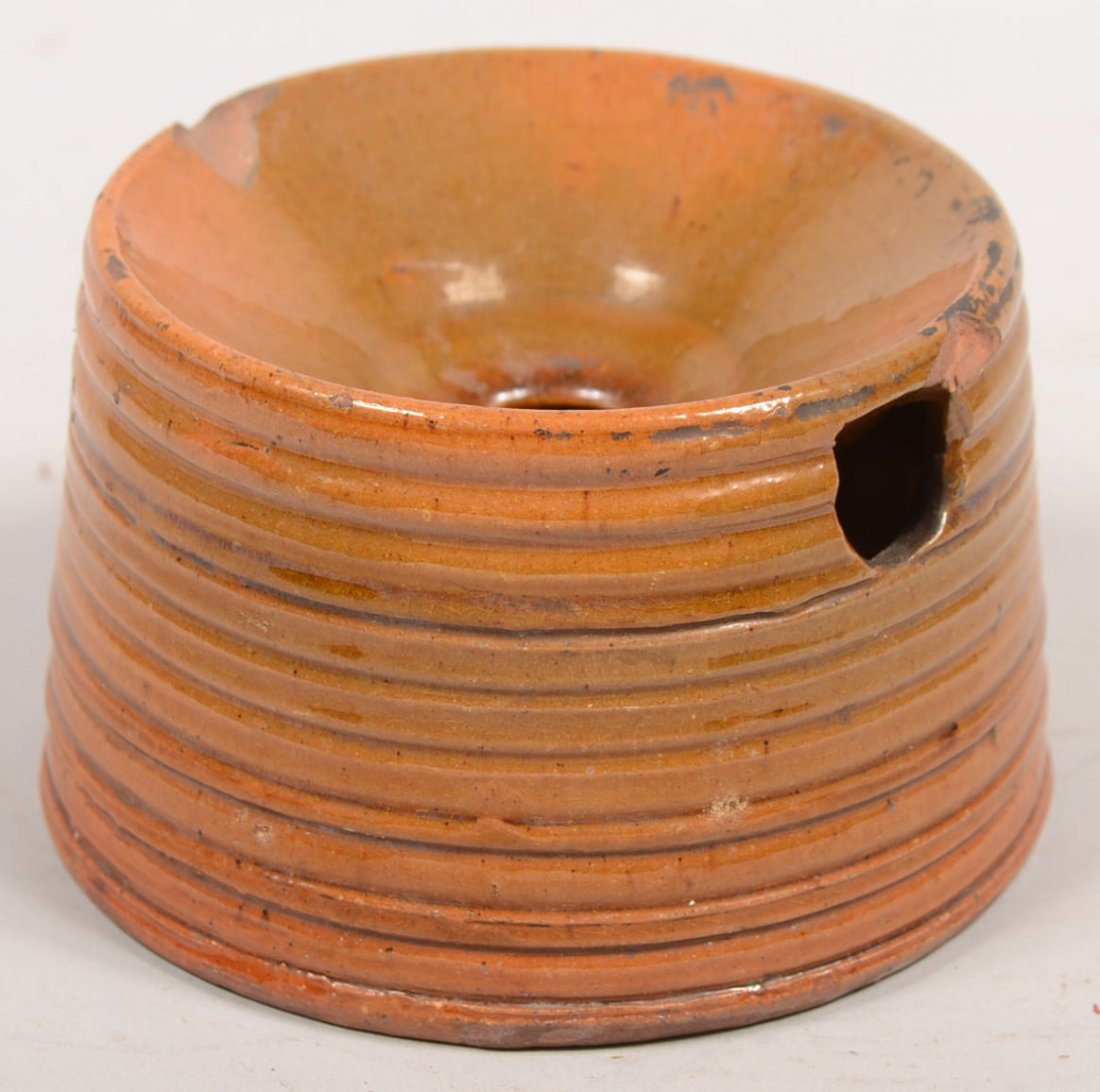 Small Redware Bee Hive Shaped Spittoon. Ribbed con: Small Redware Bee Hive Shaped Spittoon. Ribbed conical form has recessed top with hole and half round hole on side for drainage. Sat glaze. 3"h. X 4 3/4"dia. At base. Condition: Two chips off upper ri
