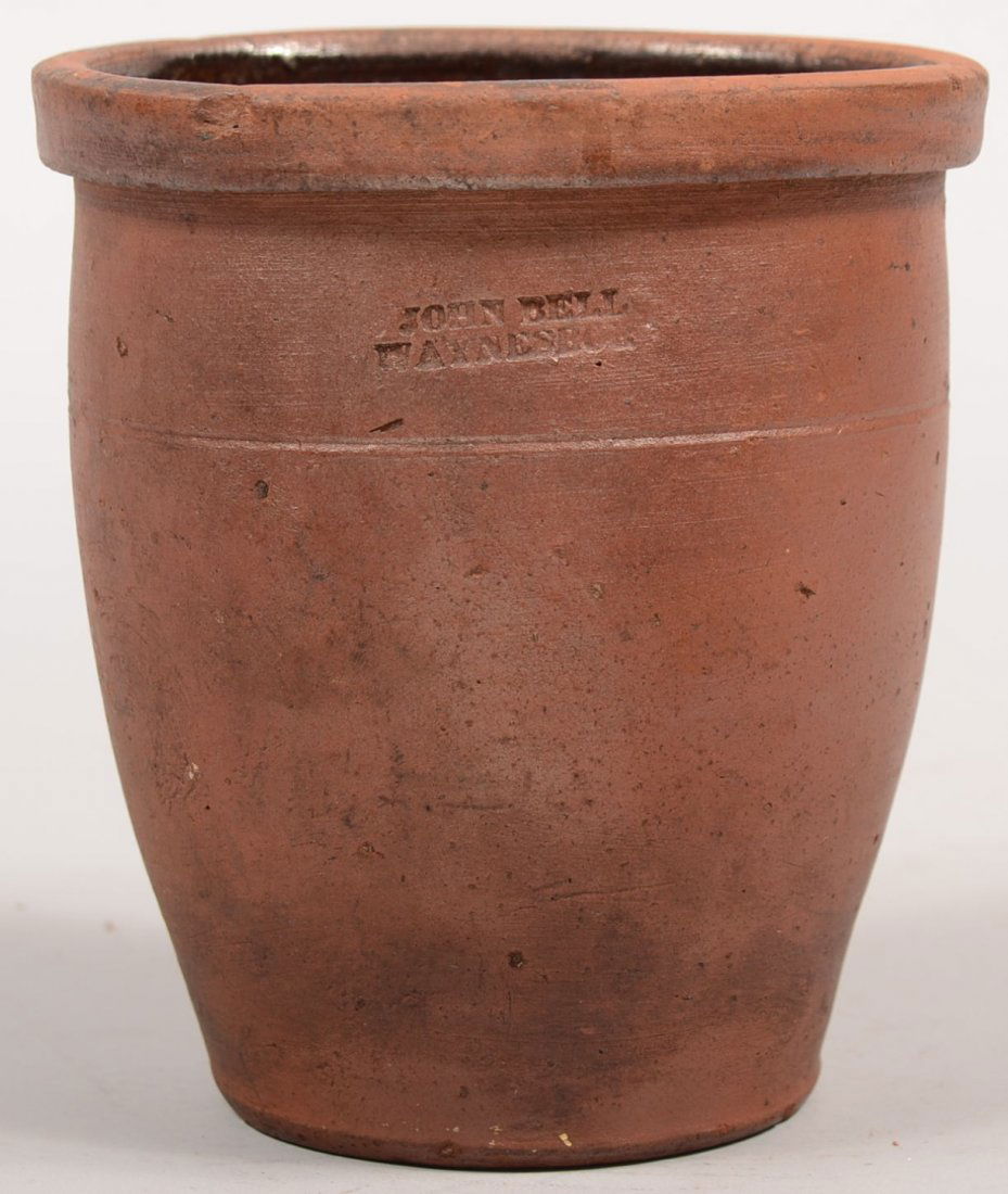 Ovoid Redware Crock Stamped John Bell. Vessel has: Ovoid Redware Crock Stamped John Bell. Vessel has square molded collar and is stamped below: "John Bell, Waynesboro." 6"h. X 4 3/4"dia. Condition: Mouth rim suffers a kiln warp. Two small chips off ri