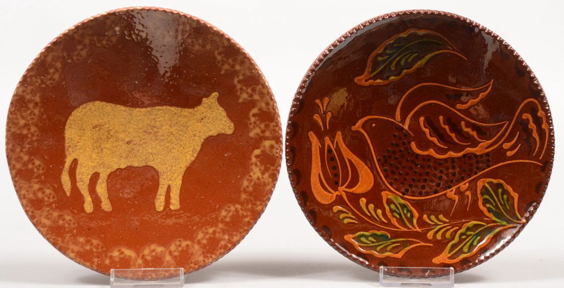 Two Different C.N. Foltz Redware Dishes. A coggle: Two Different C.N. Foltz Redware Dishes. A coggle rim with yellow sponge decoration and a cow silhouette. Back is signed and stamped with 1982. 1 3/8"h. X 7 1/2"dia. Along with a tightly drawn bird wi