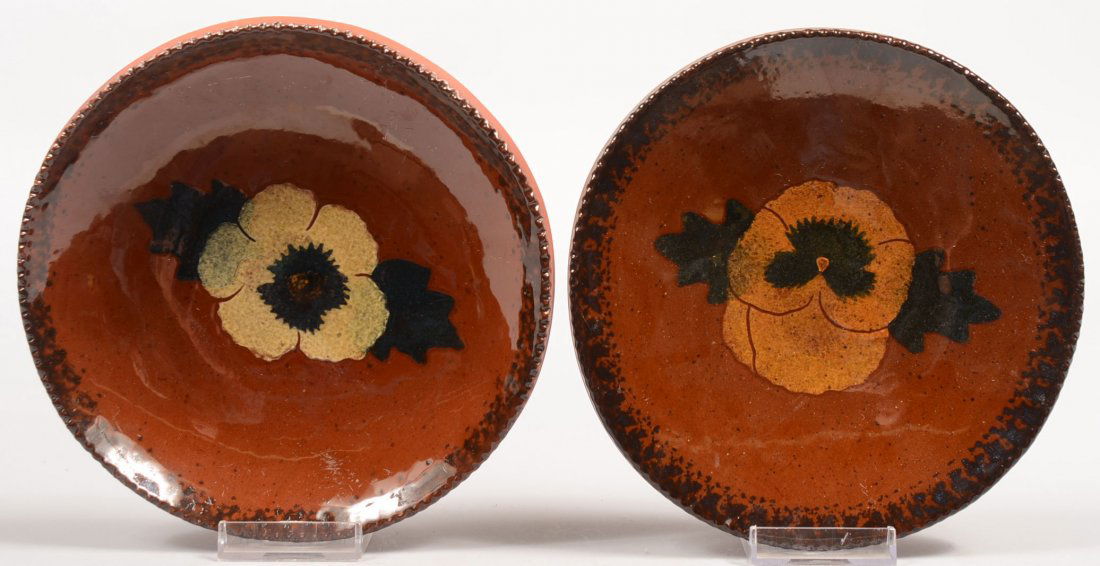 Two Ned Foltz Redware Dishes. Each has manganese s: Two Ned Foltz Redware Dishes. Each has manganese sponging around a coggle rim and a slip flower on center. A pansie and a mayflower. Both have signiture and Pottery stamp verso and are dated 1994 & 95